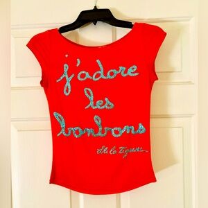 Cute bright orange top w/ blue glitter writing; bought @ a boutique in Paris🧡🩵